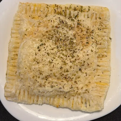 Empanada de camarón y queso de masa de hoja, con orégano