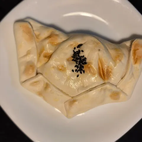 Empanada de pollo, queso y ciboulette con sésamo negro