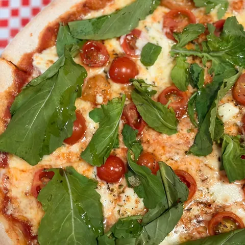 Pizza Cuica con tomate cherry, queso de cabra y rúcula