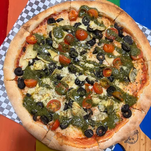 Pizza vegana con pesto, tomate cherry, aceituna negra y alcachofa
